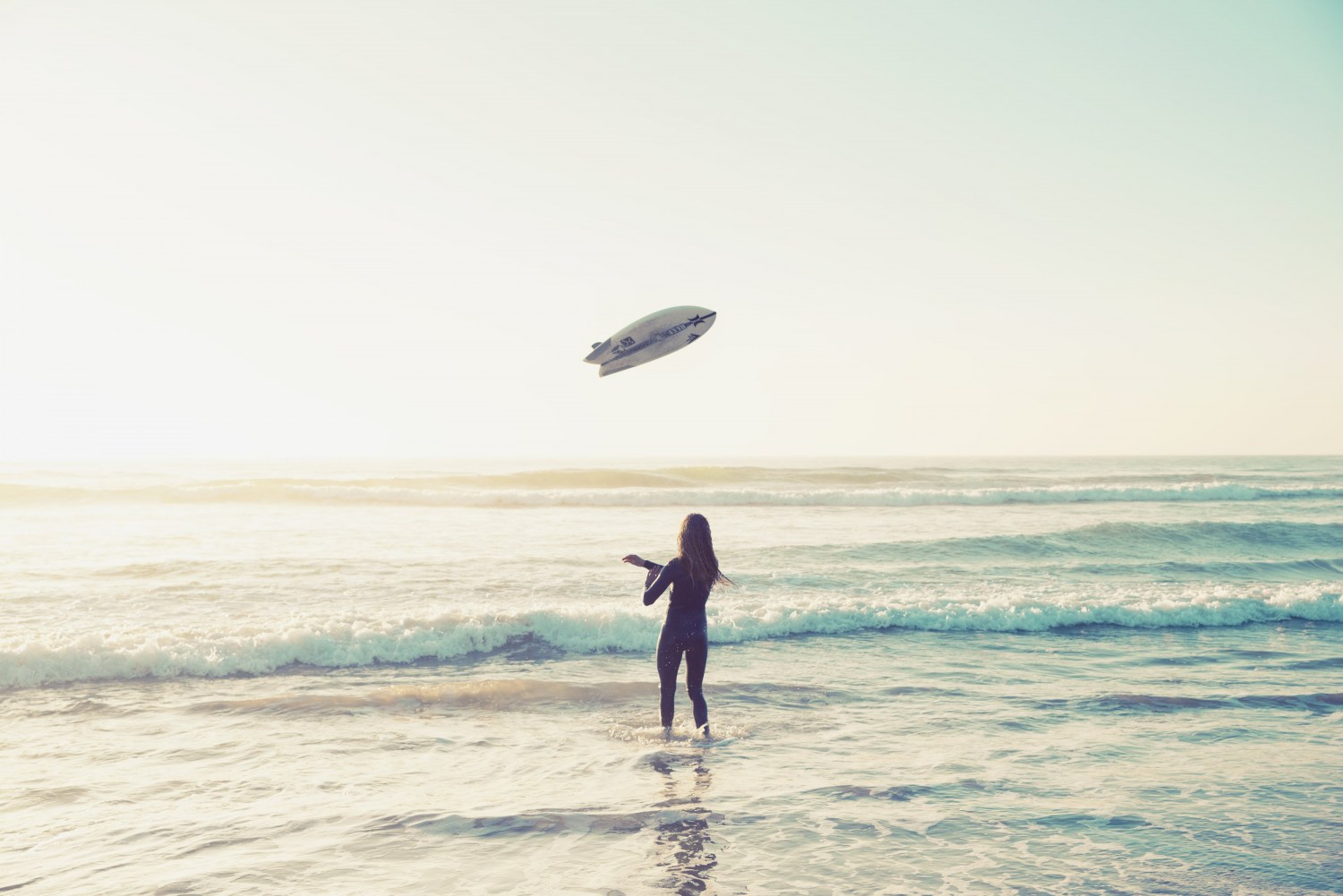 Beach freely throwing surfboard